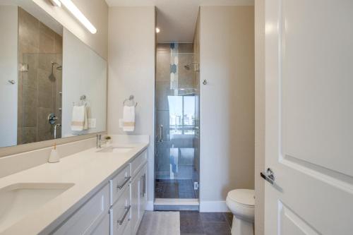 ein weißes Badezimmer mit Waschbecken und Dusche in der Unterkunft Rooftop Deck and Hot Tub Walkable Denver Townhome in Denver