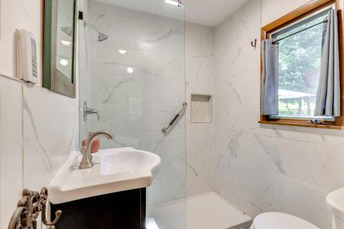 a white bathroom with a sink and a shower at Walk to Lake Harmony Home with Hot Tub and Fire Pit in Lake Harmony