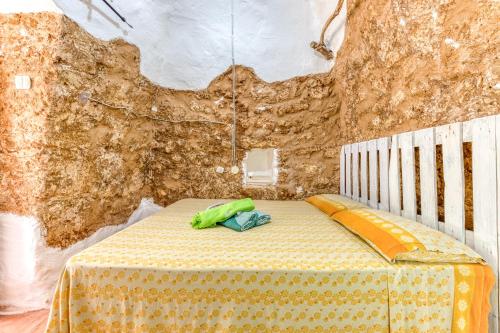 a room with a bed with a table and a wall at Guest House Fontanelle in Ugento