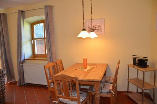 a dining room with a wooden table and chairs at Hofgut Wollin GmbH in Putgarten