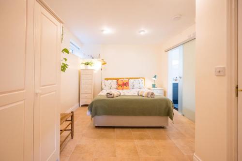 a bedroom with a bed with a green bedspread at Sedge Cottage "Barn", Reydon in Reydon