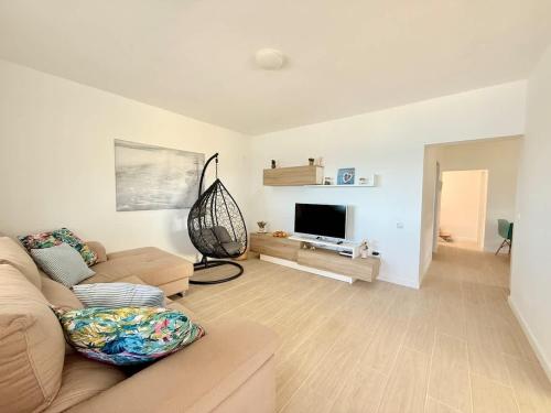 a living room with a couch and a flat screen tv at House on the beach WIFI Ajuy Fuerteventura in Ajuy