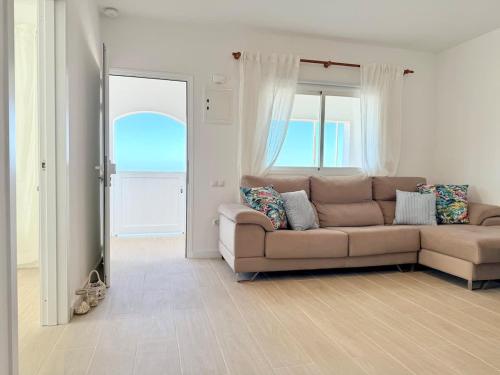 a living room with a couch and a large window at House on the beach WIFI Ajuy Fuerteventura in Ajuy