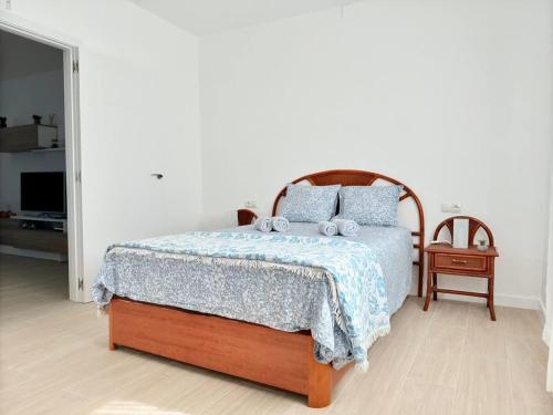 a bedroom with a bed with a blue comforter at House on the beach WIFI Ajuy Fuerteventura in Ajuy