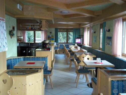 une salle à manger avec des tables et des chaises dans un restaurant dans l'établissement Casa per Ferie Villa Romagna, à Pozza di Fassa