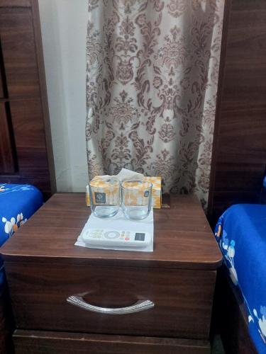 a table with two glasses on top of a nightstand at HostHub Guest House Gulshan iqbal in Karachi