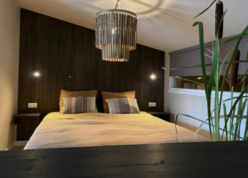 a bedroom with a large bed and a chandelier at De Meuleberg Boutique Suites 