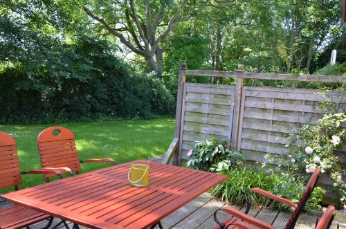 a wooden table and chairs in a yard with a fence at Hofgut Wollin GmbH in Putgarten