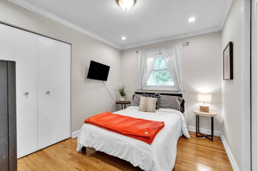 a white bedroom with a bed and a window at The Elegant Ranch by Granger Gardens in Ann Arbor