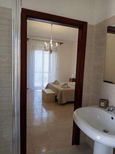 a bathroom with a bed and a sink and a mirror at Da Ninnilla Holiday Home Scafati in Scafati