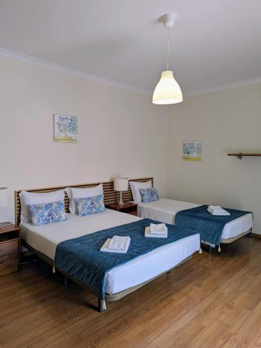 a room with two beds and a lamp and wooden floors at Casa Sousa in Lagos