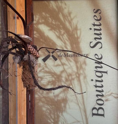 a sign on the side of a door with a tree at De Meuleberg Boutique Suites 