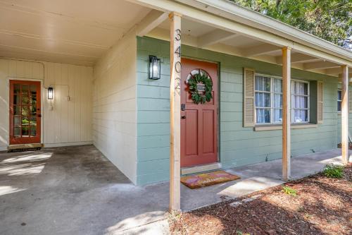 a house with a red door with a wreath on it at Cozy Home Close to UF, Shands & Everything in GNV in Gainesville