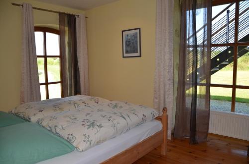 a bedroom with a bed and a large window at Hofgut Wollin GmbH in Putgarten