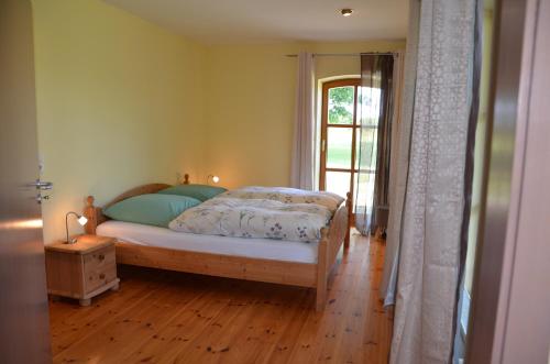 a bedroom with a bed and a window at Hofgut Wollin GmbH in Putgarten