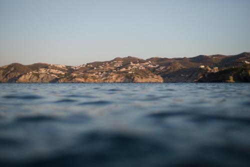 a group of houses on top of a mountain on the water at Peninsula Resort & Spa in Agia Pelagia