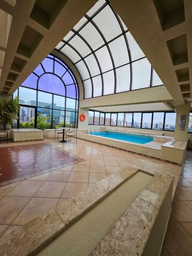 a swimming pool in a building with a glass ceiling at EstanPlaza Nações Unidas - SP Classic - apto 302 in Sao Paulo