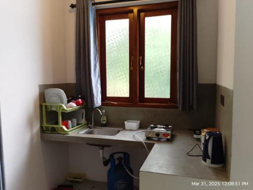 a kitchen counter with a sink and a window at The Nest in Weligama
