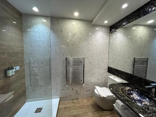 a bathroom with a shower and a toilet and a sink at Hotel Històric in Girona