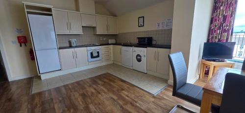 a large kitchen with white cabinets and a washer and dryer at The Courtyard Apartments in Carrick on Shannon