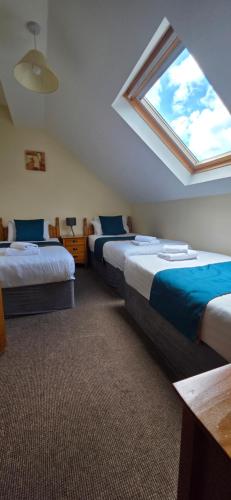 a attic bedroom with two beds and a window at The Courtyard Apartments in Carrick on Shannon