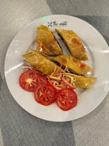 a plate of food with tomatoes on a table at The Nests Busiro in Wakiso