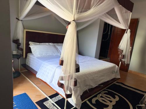 a bedroom with a bed with a canopy at The Nests Busiro in Wakiso