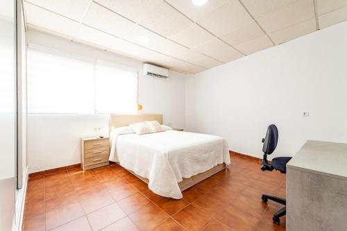 a bedroom with a bed and a desk and a chair at Apartmento Gonzalez de Aguilar in Ayamonte
