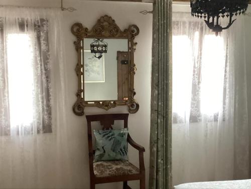 a mirror and a chair in a room with windows at La Bricola in Cavallino-Treporti