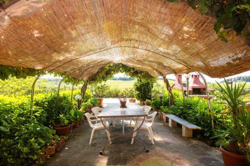 a patio with a table and chairs under a large umbrella at Agriturismo Osea in Monteriggioni