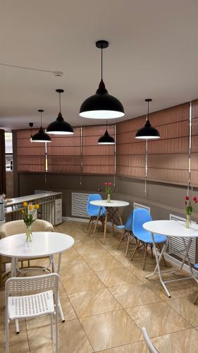 a dining room with tables and chairs and lights at Байтерек рядом Министерство in Astana
