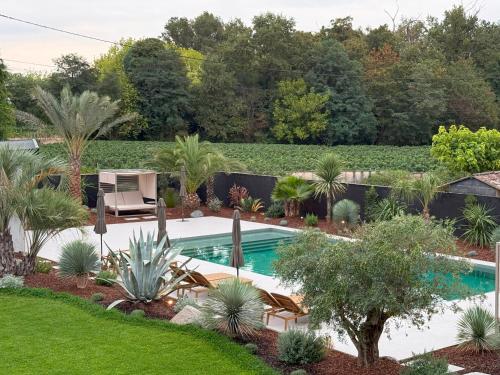 a swimming pool in a garden with plants at 537 Saint Emilion - Luxury Guest House in Saint-Laurent-des-Combes