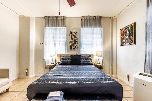 a bedroom with a large bed and two windows at Casa Bonita Apartments in Long Beach
