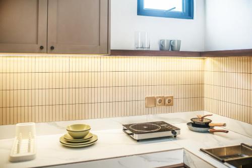 a kitchen with a stove and some dishes on a counter at Le Jardin CoLiving B3 - Upscale Apt, Canggu center in Canggu