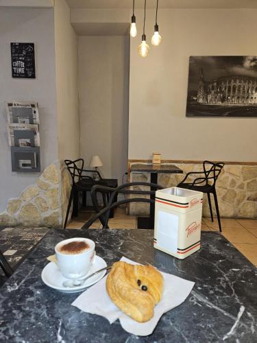a table with a cup of coffee and a croissant and a cup at Il nido di Elisa in Albano Laziale