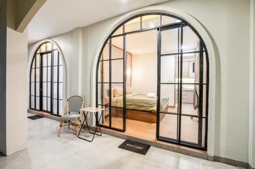 a room with two large windows and a bed at Le Jardin CoLiving B3 - Upscale Apt, Canggu center in Canggu