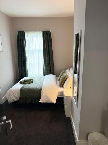 a small bedroom with a bed and a window at The Mill House Sleep Inn in Hartlepool