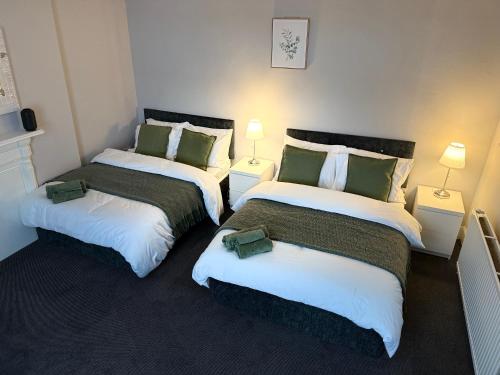 two beds in a room with two lamps at The Mill House Sleep Inn in Hartlepool