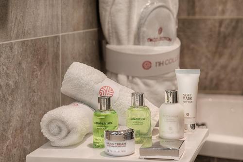 a bathroom with towels and products on a shelf at NH Collection Palazzo Cinquecento in Rome