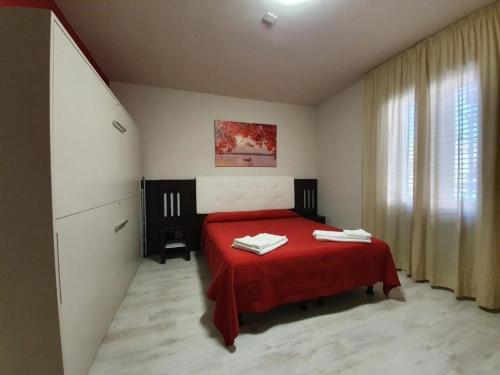 a bedroom with a red bed with a red blanket at Hotel Casale dei Greci in Biancavilla