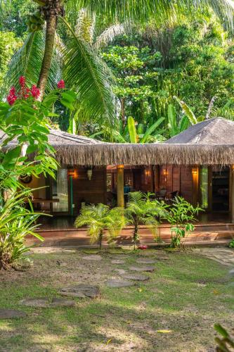 a house with a thatched roof in a forest at Bahia Soul - Casa Mutá - Barra Grande - Península de Maraú in Barra Grande