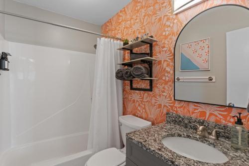 a bathroom with a sink and a toilet and a mirror at Dog Friendly Pool Walk to Beach in Gulf Shores