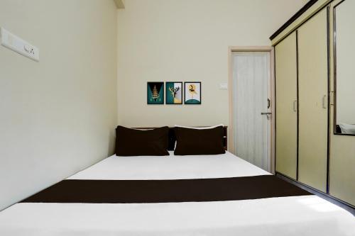 a small bedroom with a bed and a closet at Hotel O M.P GUEST INN in Nellore