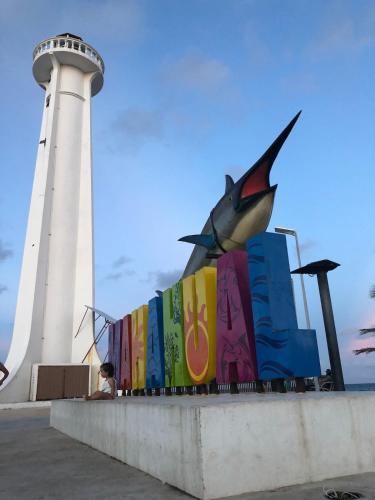 a statue of a fish in front of a lighthouse at Casa Atún Mahahual, vista al Mar Caribe in Mahahual