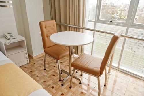 a table and two chairs in a room with a window at Mercé Hotel in Tacna