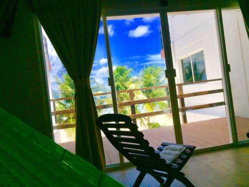 a chair in a room with a view of a balcony at Casa Atún Mahahual, vista al Mar Caribe in Mahahual