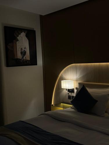 a bedroom with a bed with a headboard and a lamp at Grand Day Hotel Boutique in Al Hofuf