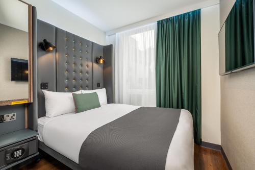 a bedroom with a large bed and a window at Point A Hotel London Shoreditch in London