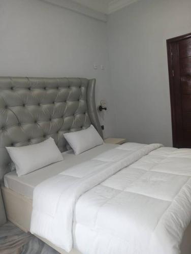 a large white bed with two pillows on it at GEFONA Guest HOUSE in Yaoundé