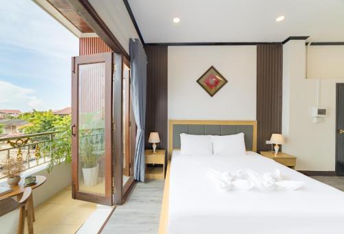 a bedroom with a large bed and a balcony at Peaceful 2 Hotel in Vientiane